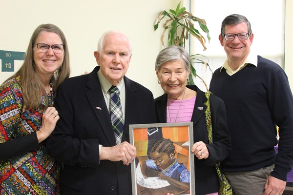 Mr. and Mrs. Seazholtz and Mr. and Mrs. Cicone hold gift painted by DLEACS student.